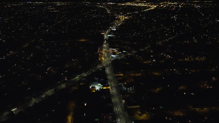 Aerial view of a nighttime city with highways