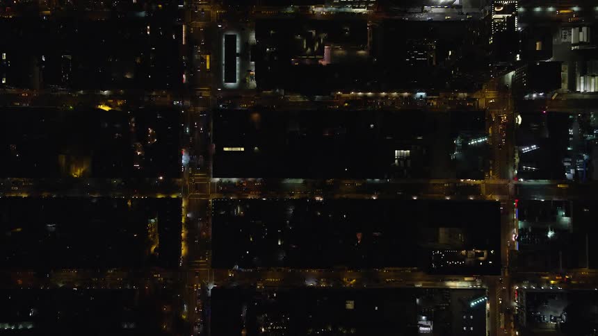 Aerial view of the streets and skyscrapers of a metropolis at night