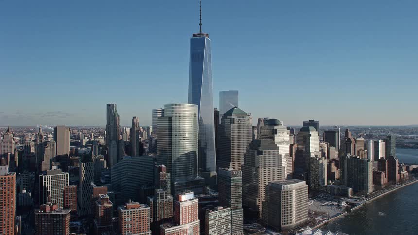 The sun shines upon towers and skyscrapers of a metropolitan city along the coast