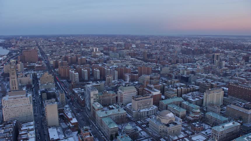 Aerial panorama of a snowcovered metropolis by the seaside under a purple dawn sky