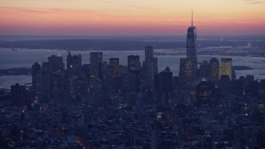 Aerial view of a metropolis by the sea with a reddish dawn sky