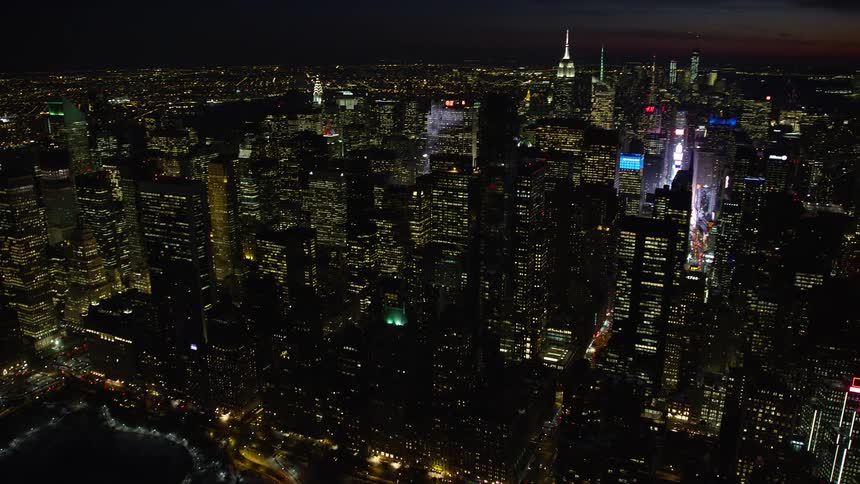 A city is shown lit up at night via aerial view