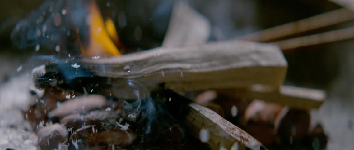 Firewood slowly burning in a campfire