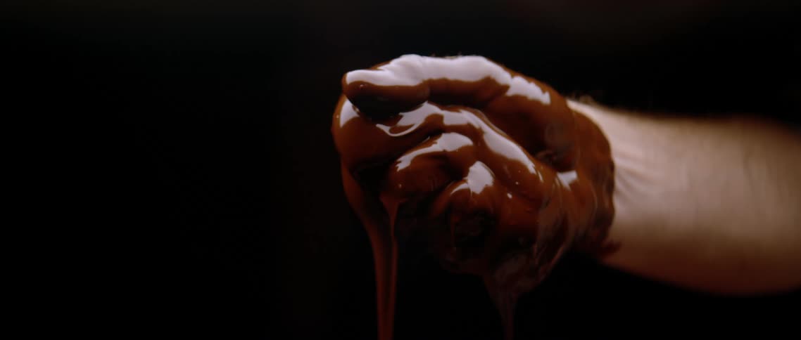 A person has viscous red bloodliquid liquid completely engulfing their fist