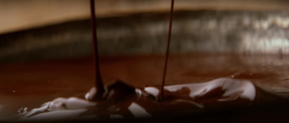 Chocolate drops falling into a bowl