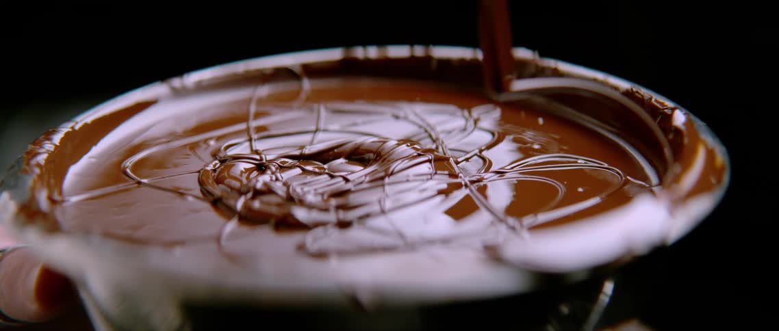 The chocolate slowly drips in the bowl