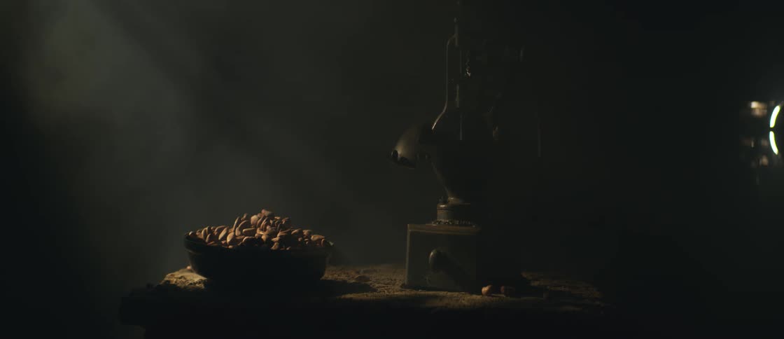 A bowl with food being illuminated by overhead light and smoke