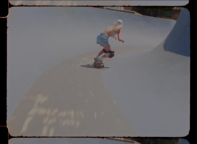 A woman is skating in the skate park