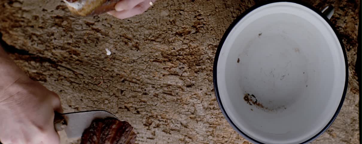 Person with a knife cutting a cacao fruit