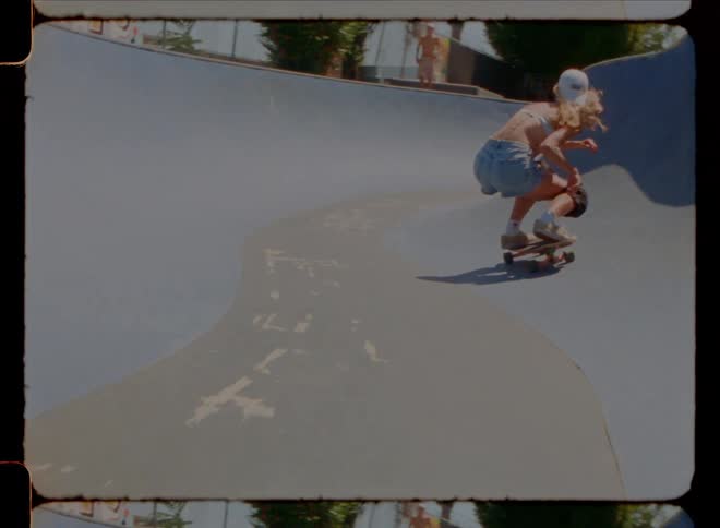 A woman is skating on the ramp in the skate park