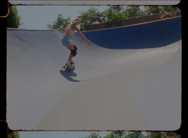 A girl skateboarding in a neighborhood during a sunny day