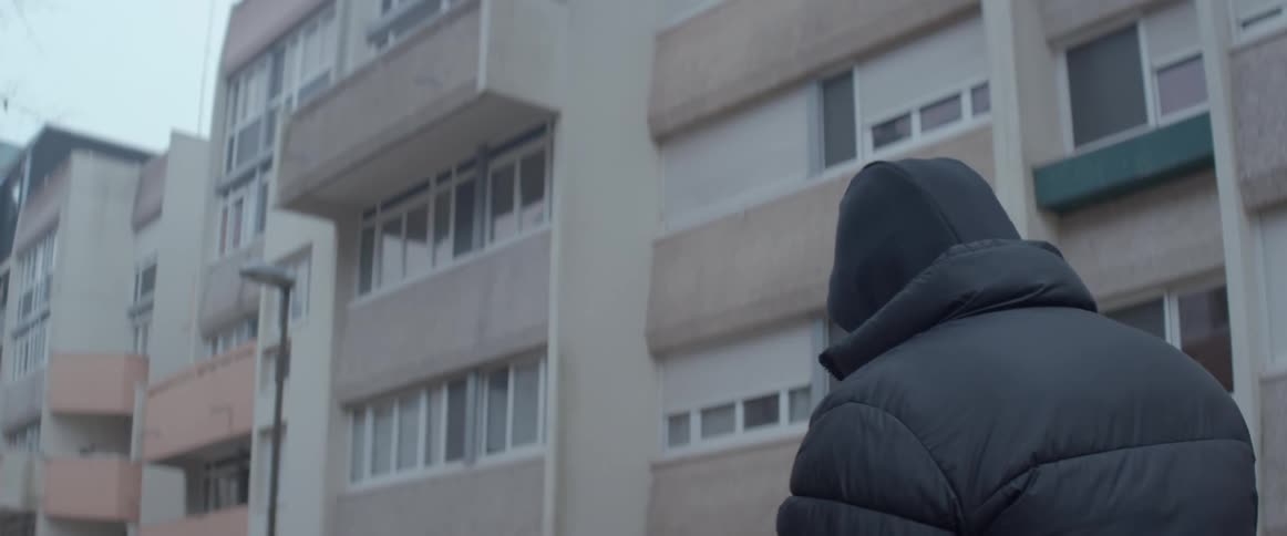 A man walks past the apartment buildings