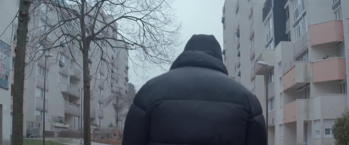 A person walking in a neighborhood with residential apartments