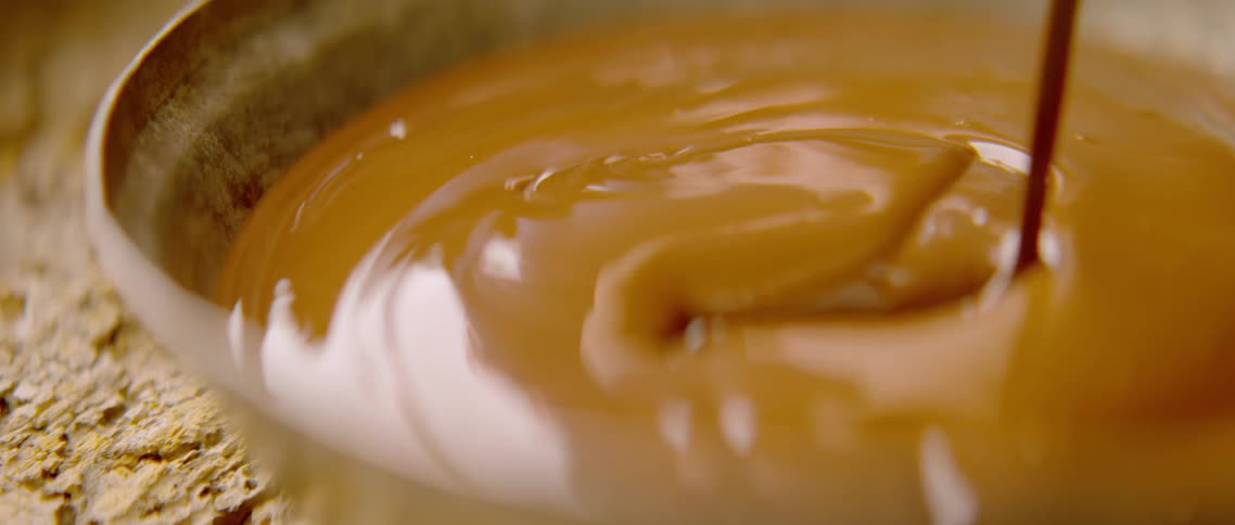Creamy caramel pouring inside a bowl