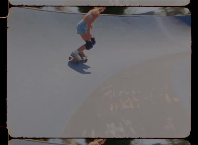 A lady skateboarding at the skate park during the day