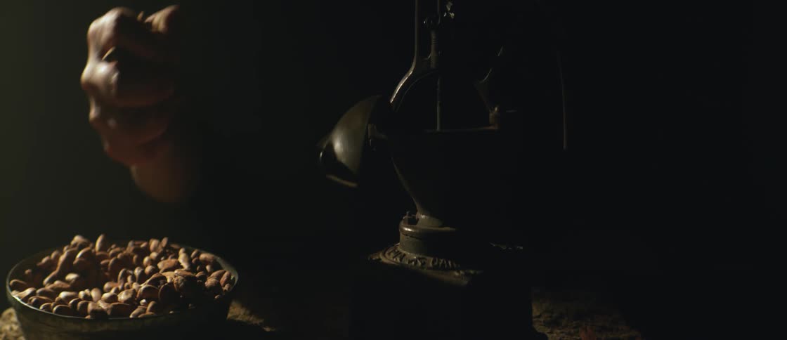 Hand of a person picking up grains from a bowl and putting them into a machine