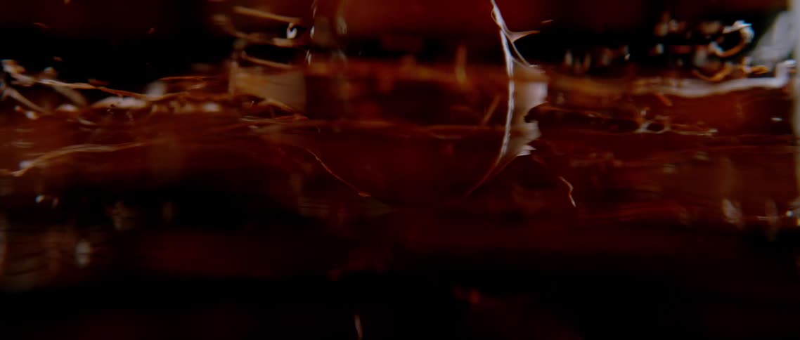 Closeup of a spatula spinning and splashing chocolate