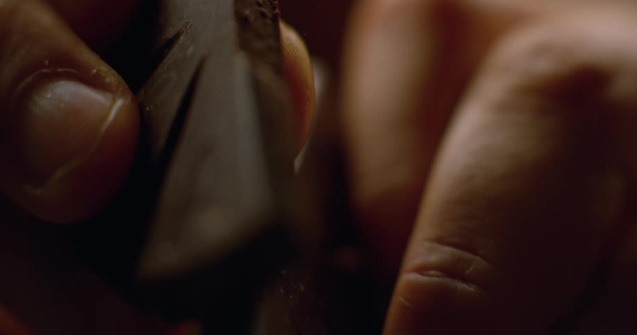 Close up of hands breaking a chocolate bar