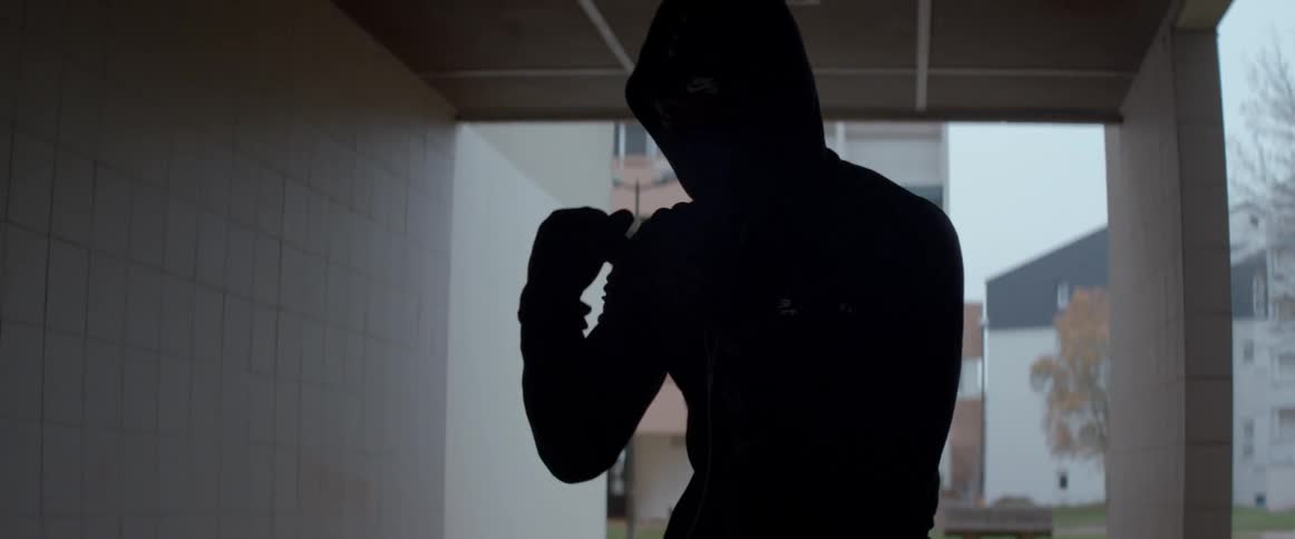 Man with a hooded sweatshirt training boxing punches