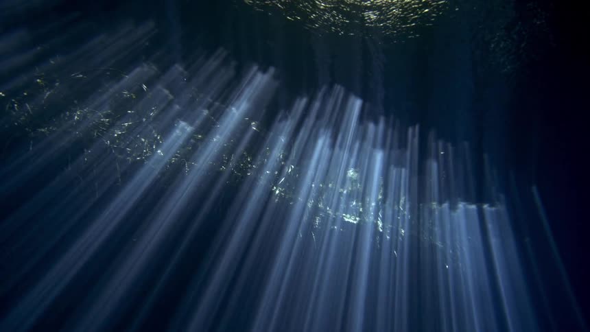 View from inside the sea in a cove with sunlight reflections