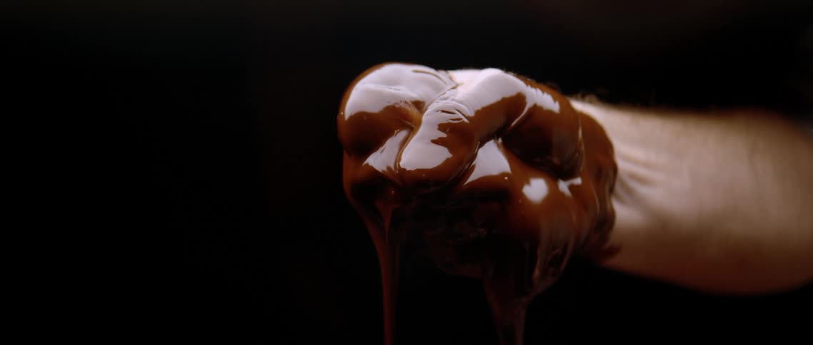 A persons hand is covered in chocolate