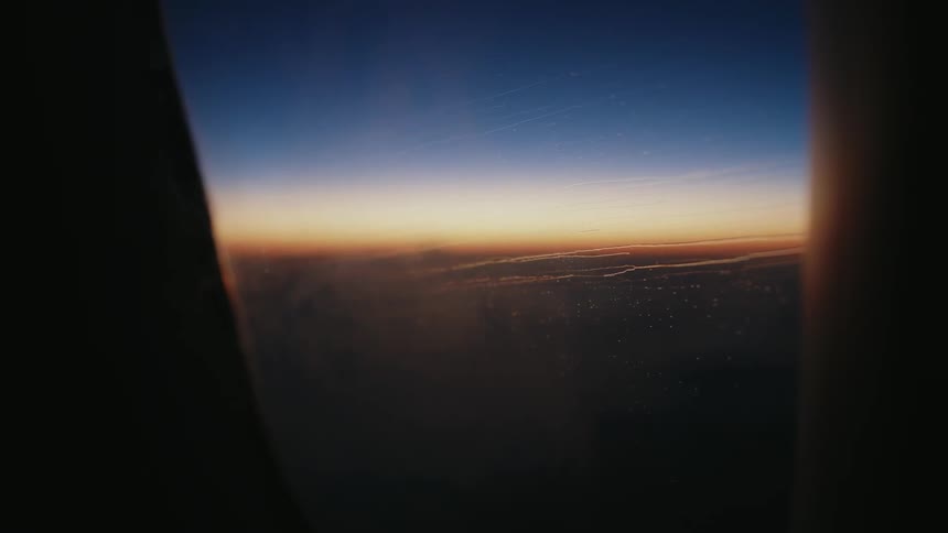 The aircraft window shows the horizon