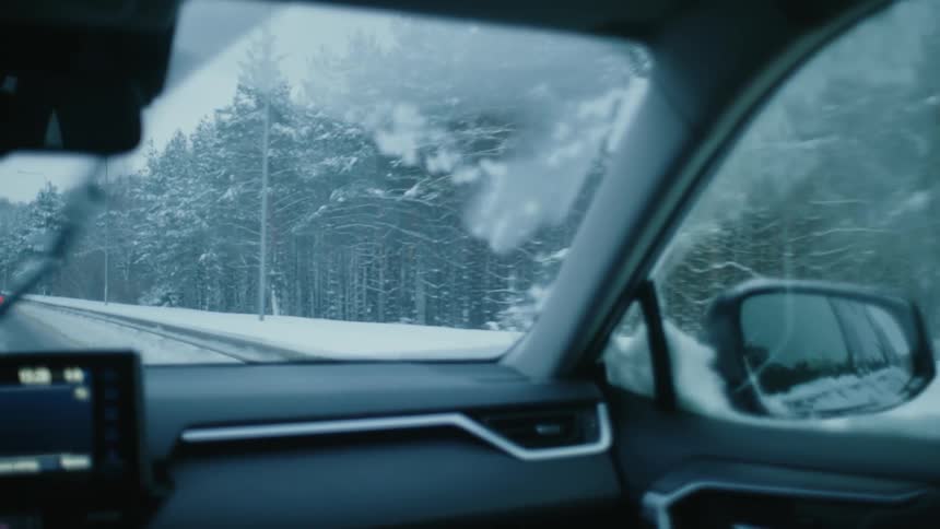 A car is driving on the highway during a storm