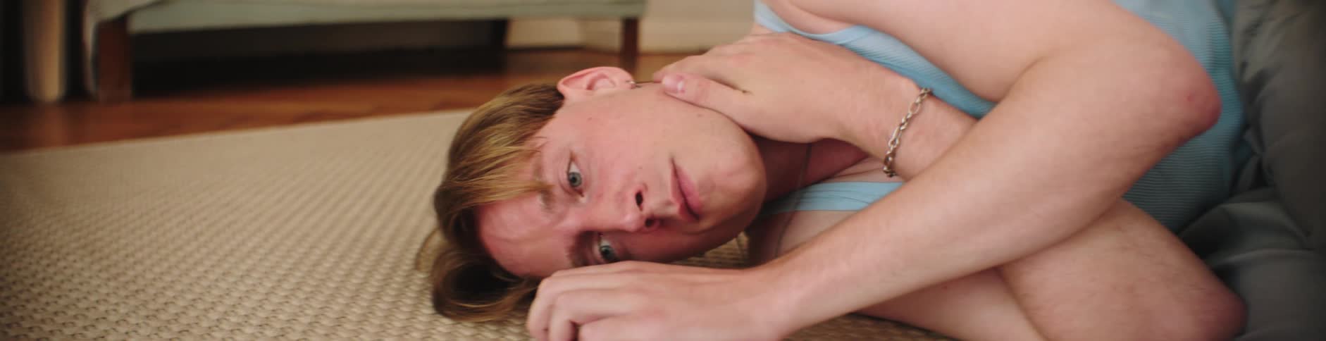 Man lays powerless on the floor of a room