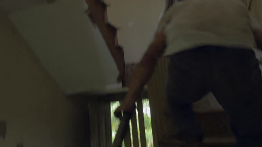 A man runs jumping through a window then dancing in the house