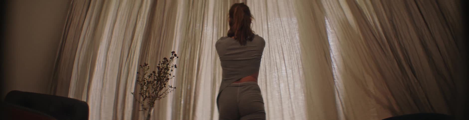 Lady walks towards the window and opened the curtains