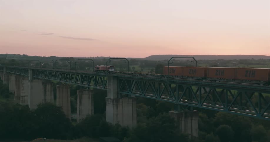 A cargo train passing through an over head bridge