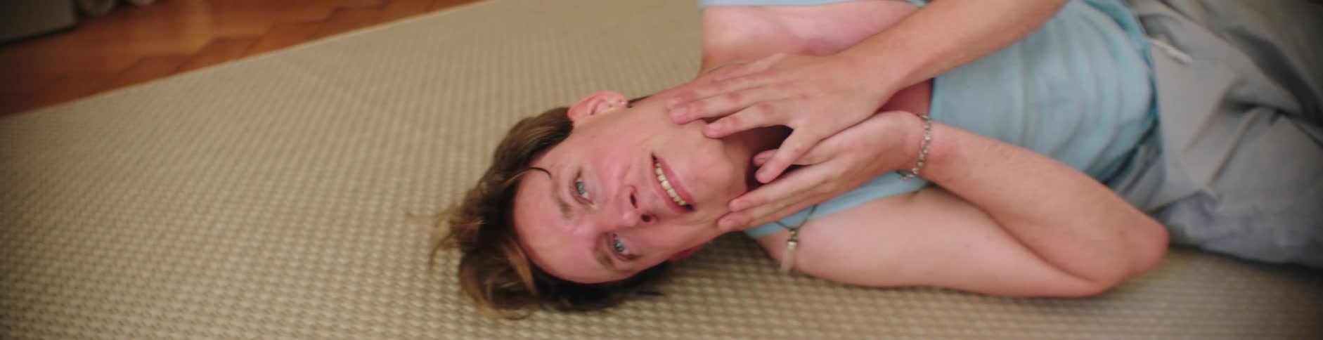 A man is lying on the floor and he is looking tired and smiling