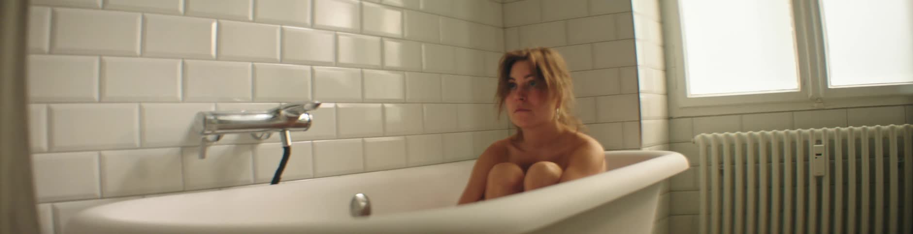 A woman is sitting in the bathtub