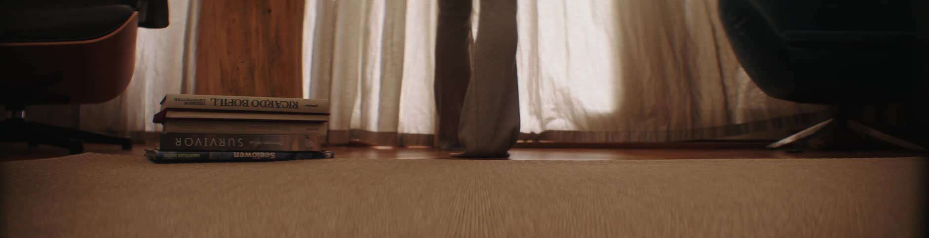 View of a persons feet walking and opening the curtain of their house