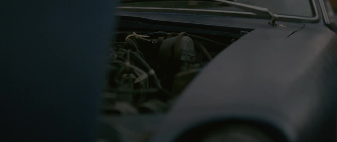 The hood of a car is open showing an engine