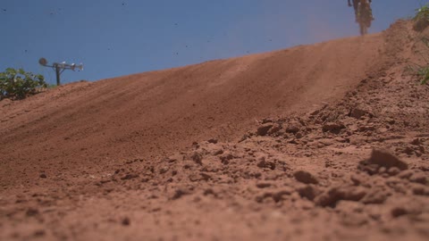 Motorcyclist jumping his dirt bike from a small hill