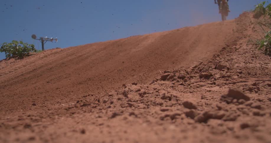 Motorcyclist jumping his dirt bike from a small hill