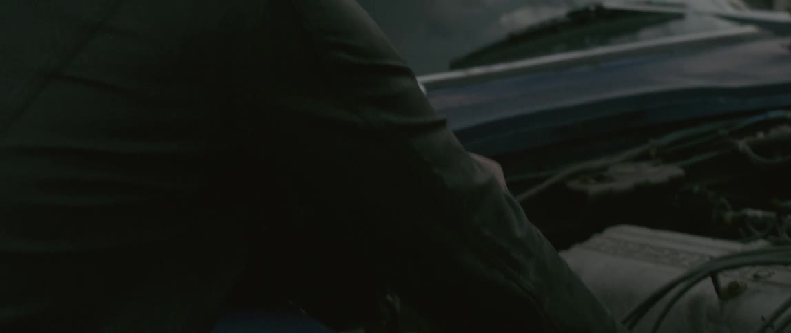 A man is working on a car engine