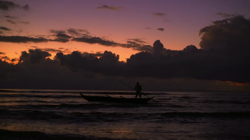 A person riding a canoe in a river in the evening