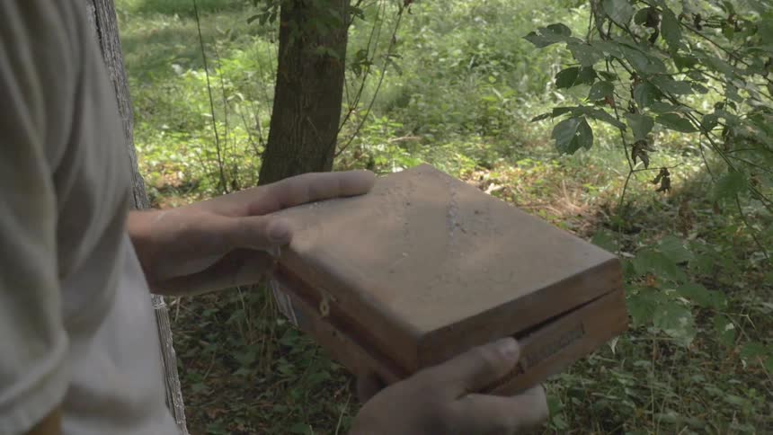 A man wipes dirt off a box