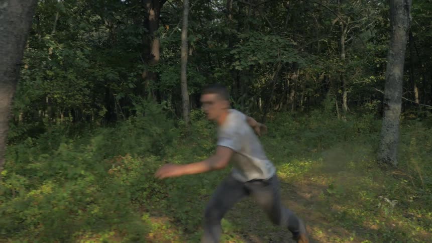 Man runs and dances through the forest
