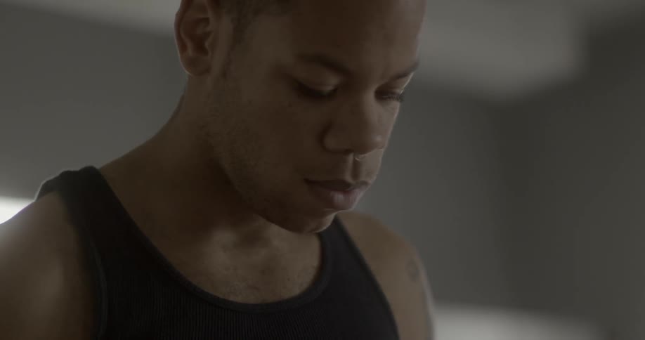 A man touches his head looking down