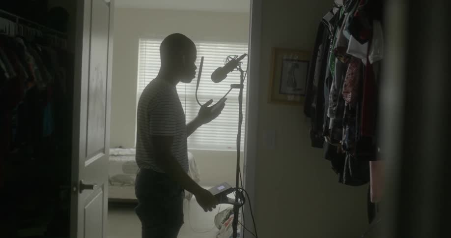 Singer singing into his microphone in his house