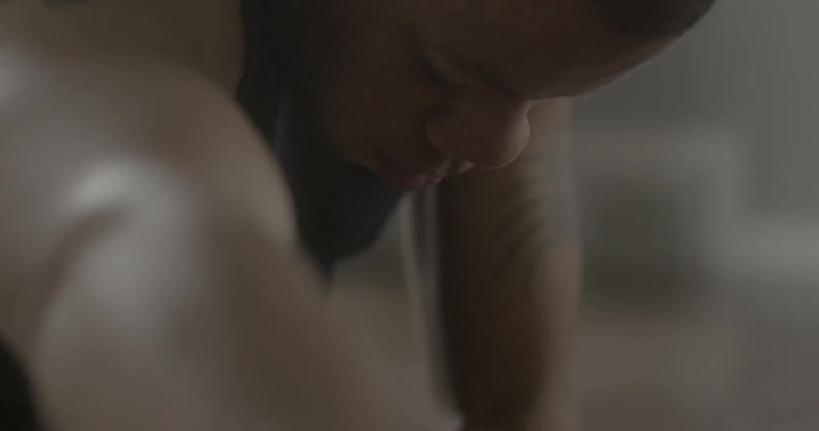 A man is leaning forward with his eyes closed