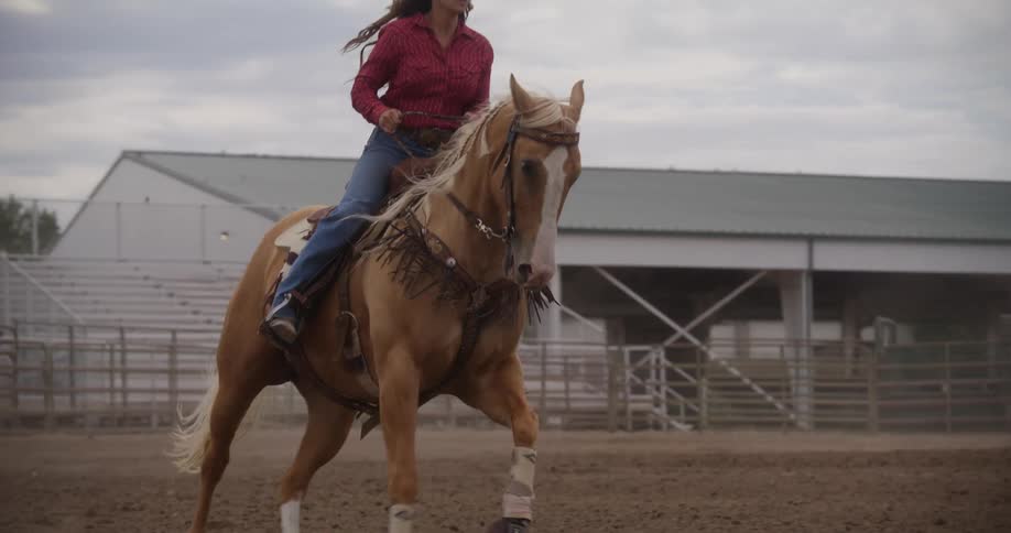 A woman riding a horse on an empty racetrack