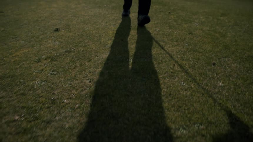 Shadow of a man holding a golf stick during the day