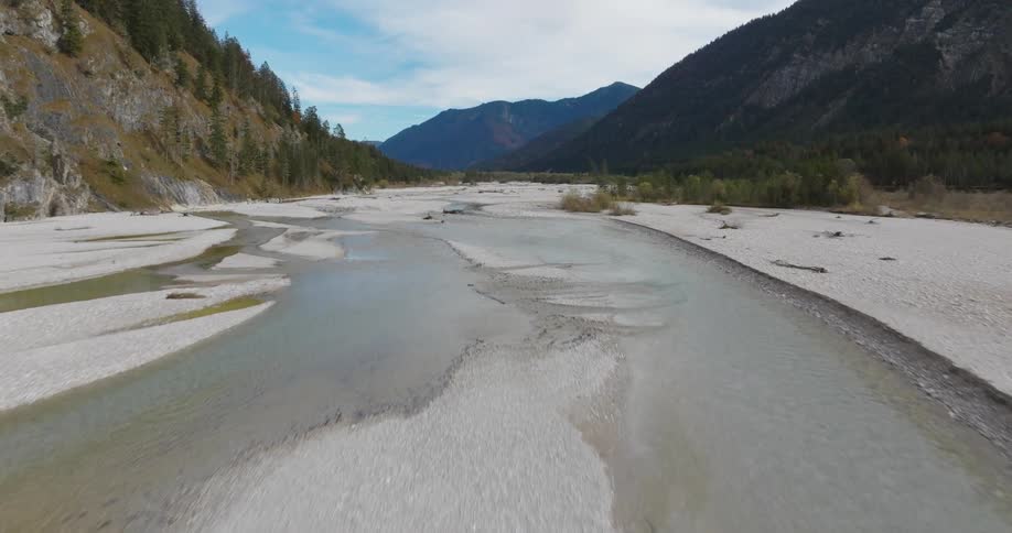 A region of an almost dry river with a gravel coast and mountains on the sides