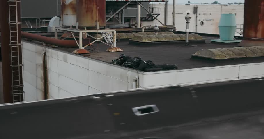 Aerial view of two police officers lying on top of buildings with guns pointed