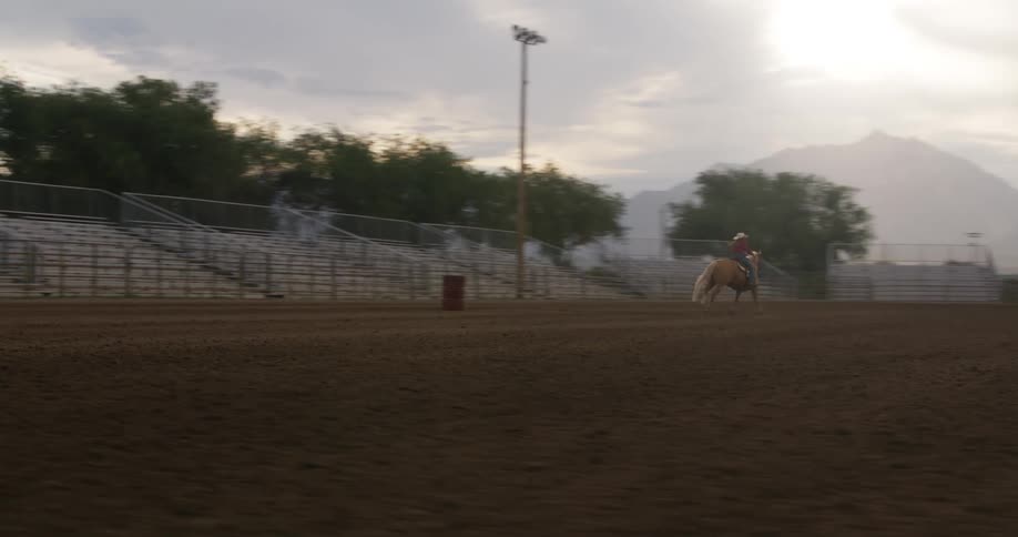 A woman riding a horse on an empty racetrack