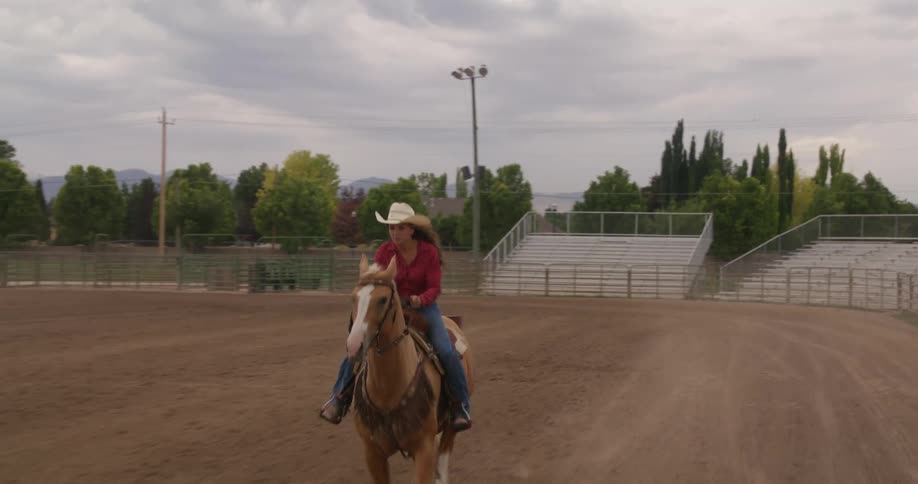 A woman is racing her horse in the ring